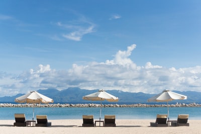 Patio umbrella and chaise longue overlooking the sea
